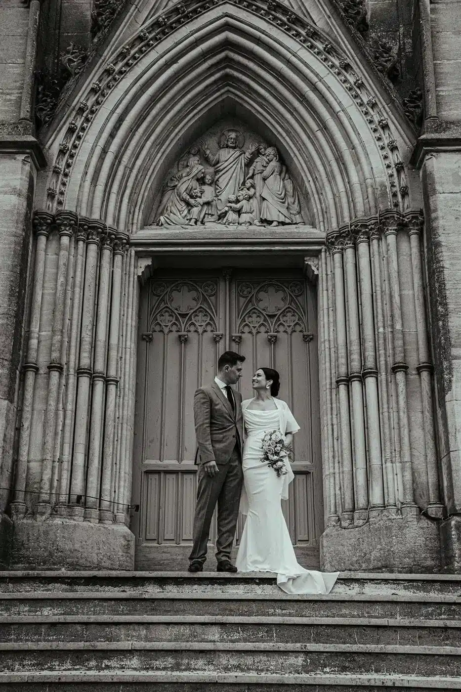 Mariés devant une église gothique, en noir et blanc