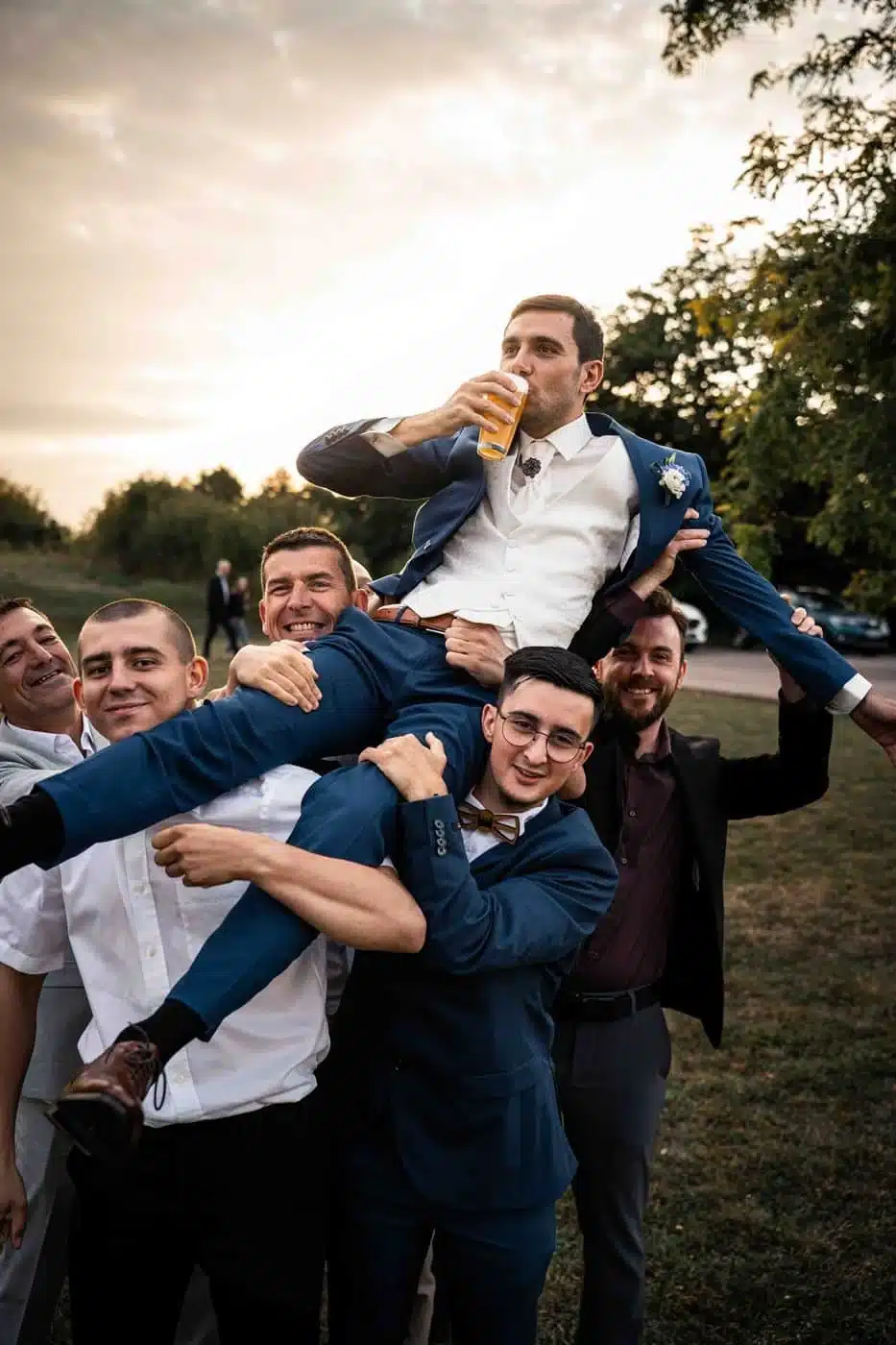 Accueil Les amis portent le marié en triomphe au coucher du soleil, mariage en Moselle