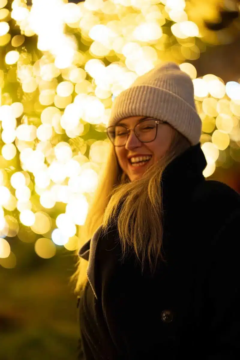 Accueil Portrait de Mégane Perrin souriante devant des lumières dorées