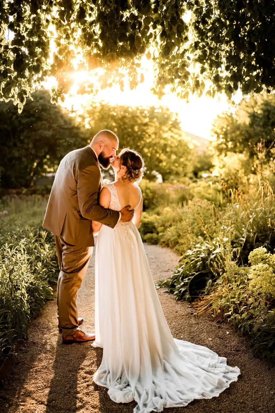 Accueil Mariés qui s'embrassent dans un jardin à la golden hour, mariage en Alsace