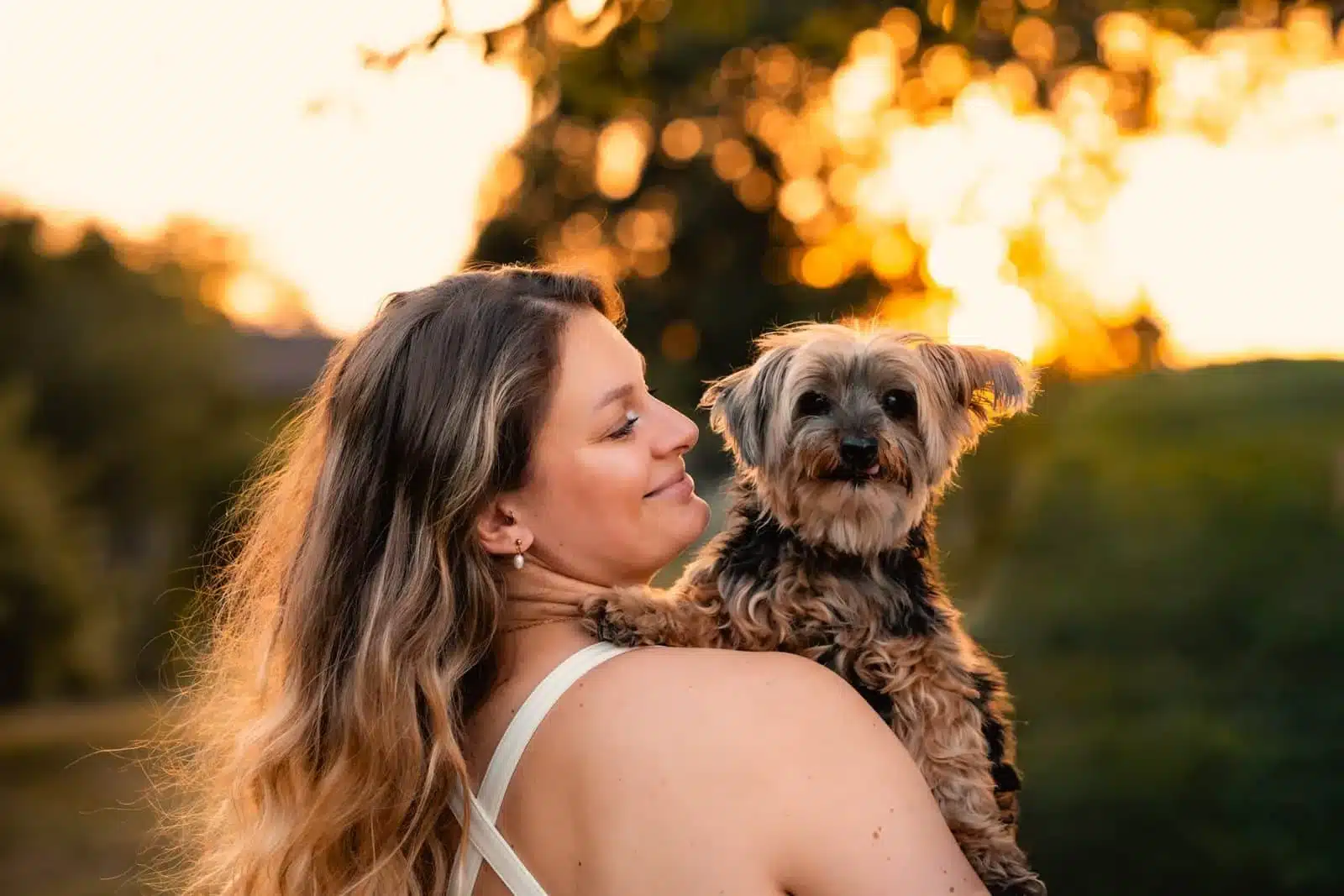 Cours photo Femme qui serre son chien contre elle à la golden hour